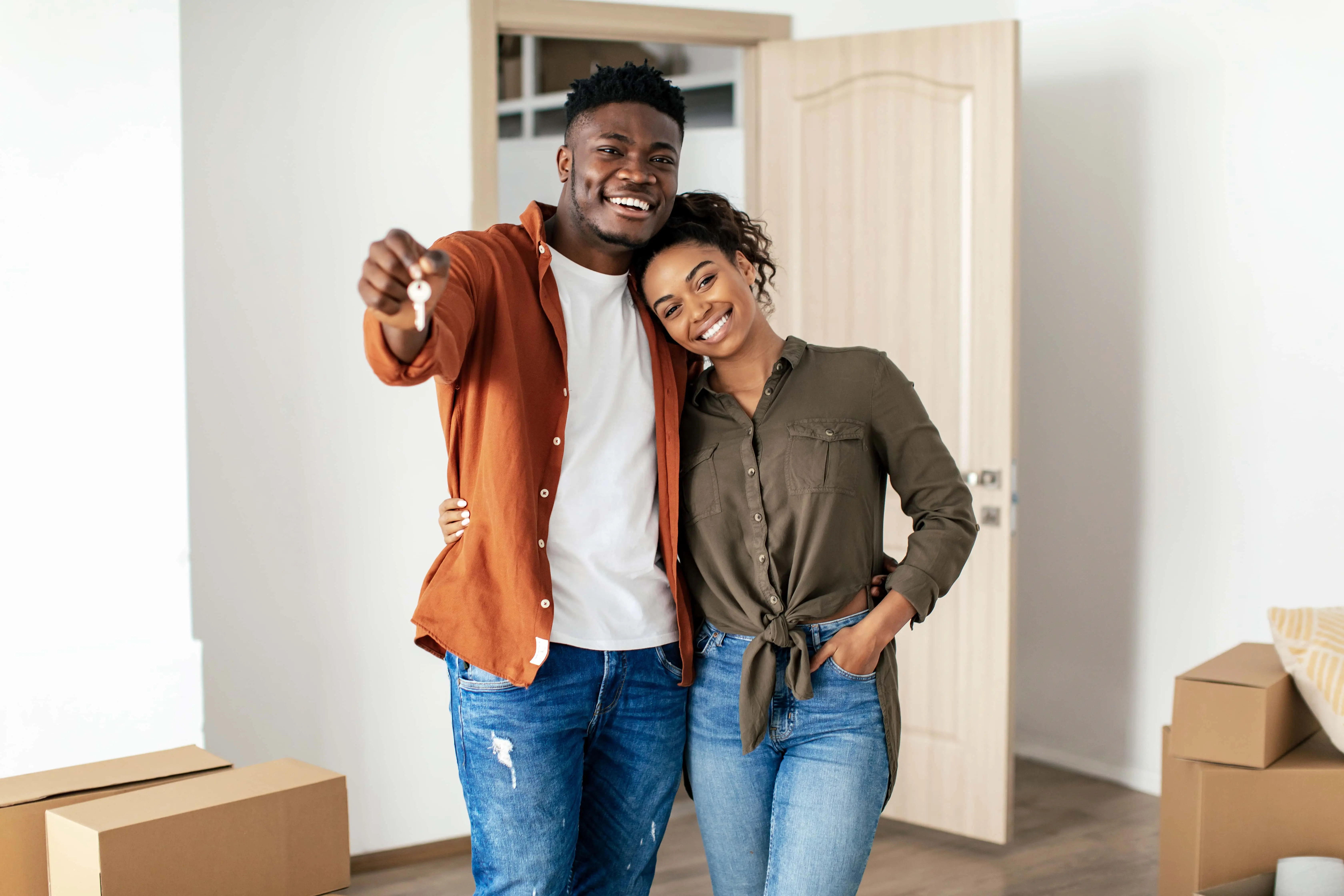 Young couple showing off keys to their new home after financing with Blackhawk Bank & Trust
